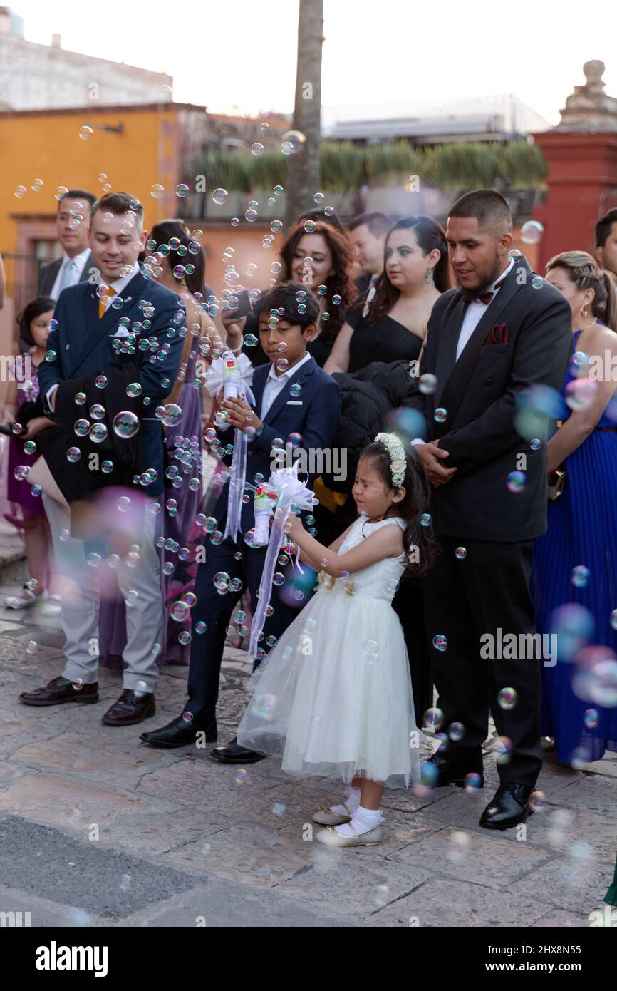 Mexiko, Guanajuato, San Miguel de Allende, junges Mädchen bei der Hochzeit bläst Blasen mit einem Blasengewehr Stockfoto
