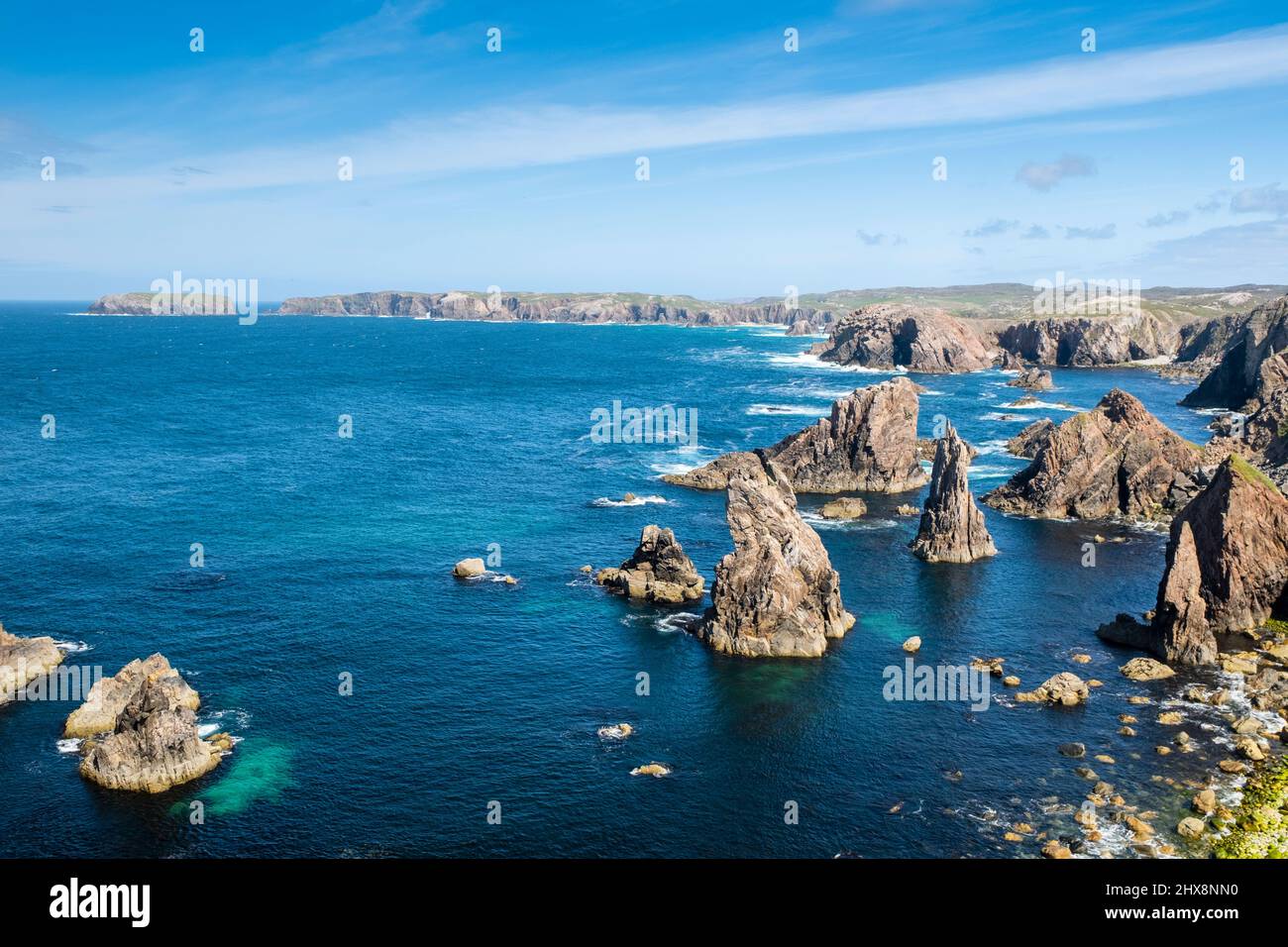 In den Mangersta Sea Stacks erheben sich Felsaufschlüsse aus dem strahlend blauen Meer. Stockfoto