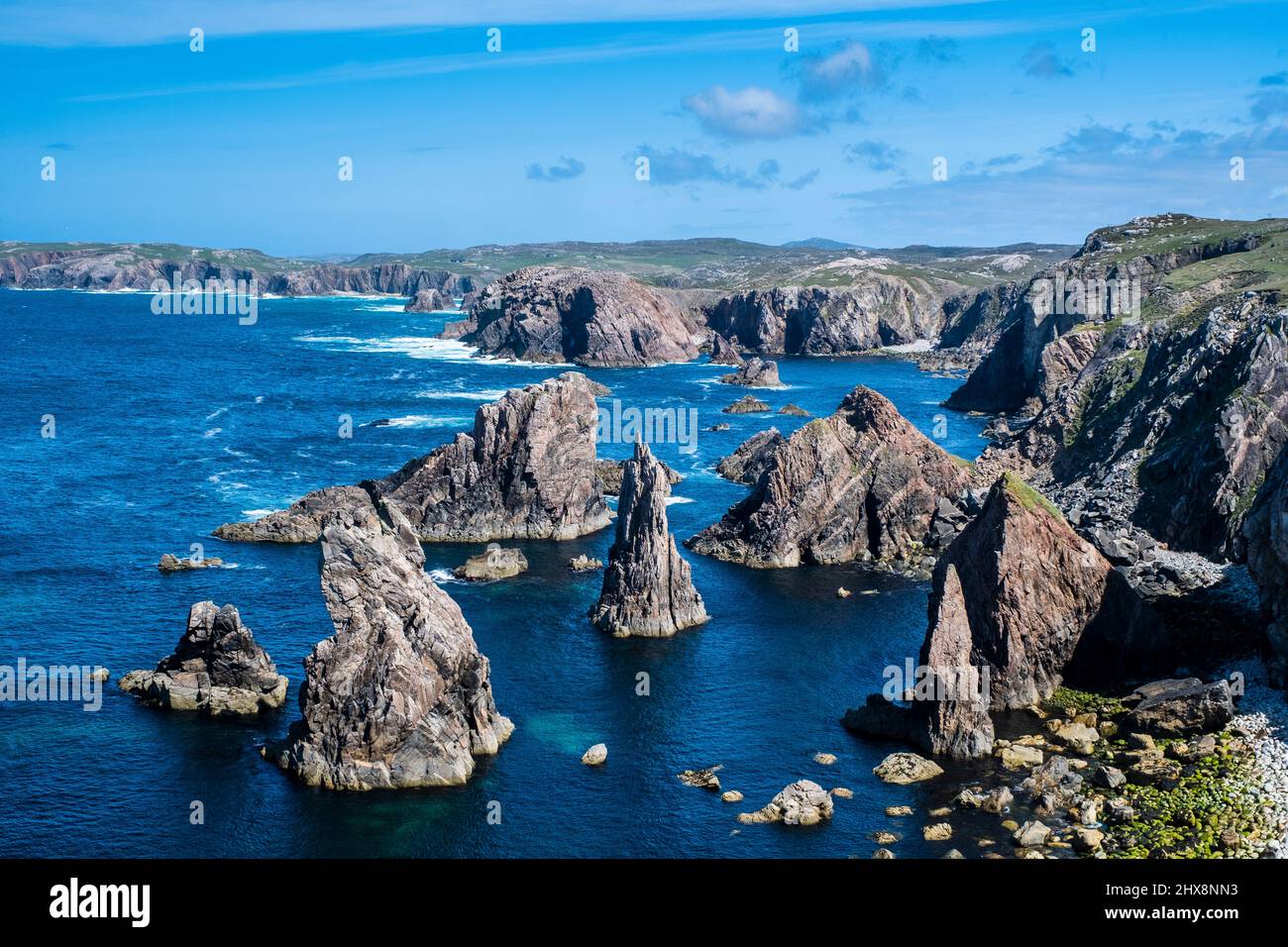 In den Mangersta Sea Stacks erheben sich Felsaufschlüsse aus dem strahlend blauen Meer. Stockfoto