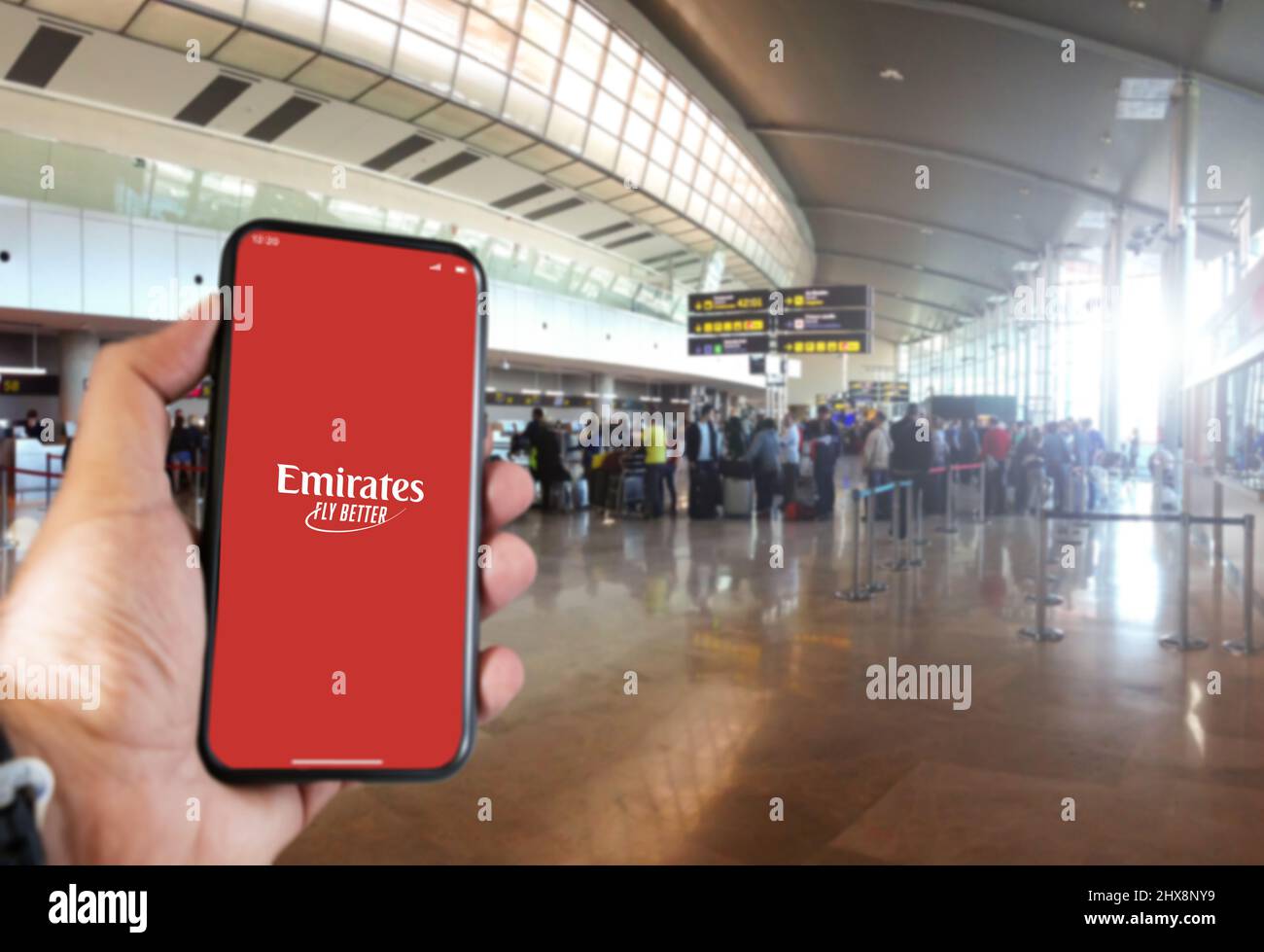 Dubai, VAE Oktober 2021: Hand halten ein Smartphone mit der Emirates App auf dem Bildschirm im Flughafen. Emirates ist die größte Fluggesellschaft der Vereinigten Arabischen Emirate Stockfoto