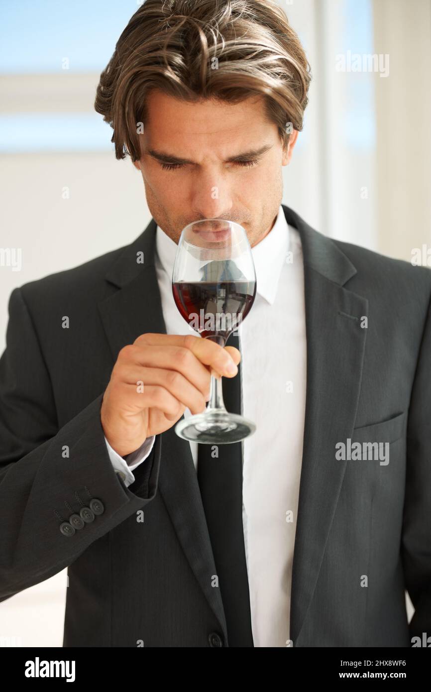 Fruchtig und doch verspielt. Ein hübscher Weinkenner, der ein Glas Rotwein genießt. Stockfoto