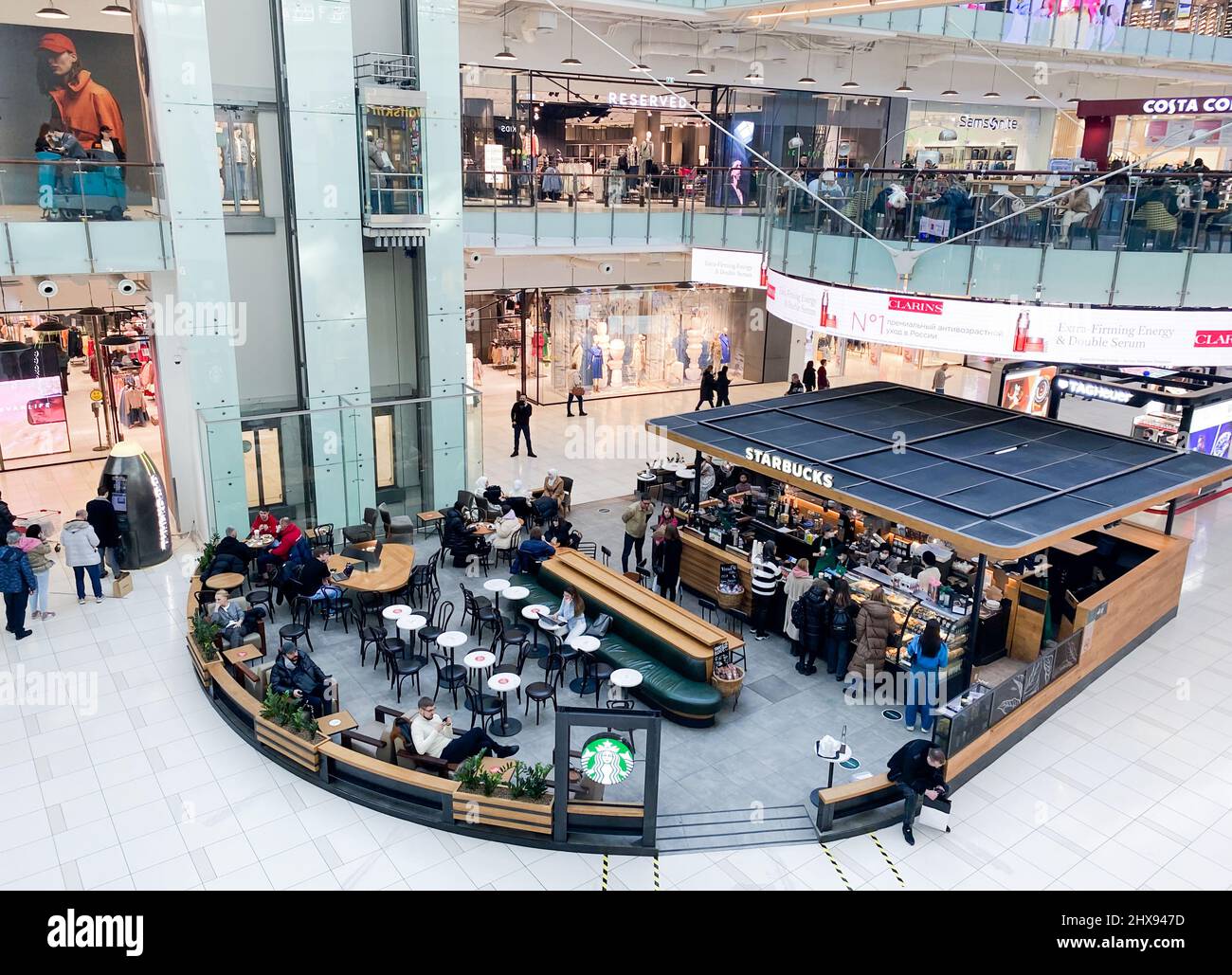 Moskau, Russland, März 2022: Draufsicht Starbuck Coffee in einem Einkaufszentrum. Die Leute sitzen, sprechen, trinken Kaffee, surfen im Internet, essen. Stockfoto