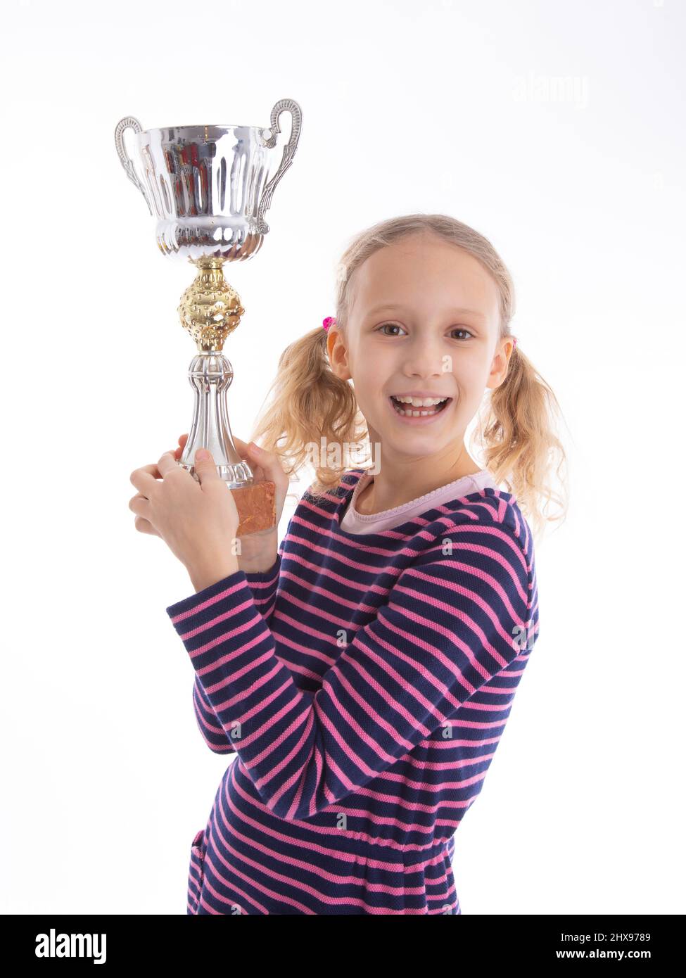 Das junge Mädchen hat einen Wettbewerb gewonnen und hält eine Trophäe in den Händen. Isolierte Studioaufnahmen mit Kopierplatz. Stockfoto