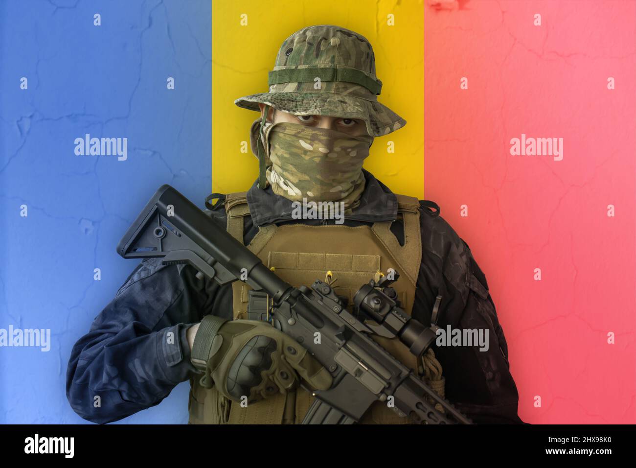 Wütender rumänischer Soldat, bewaffnet mit Gewehr und rumänischer Flagge als Hintergrund dahinter Stockfoto