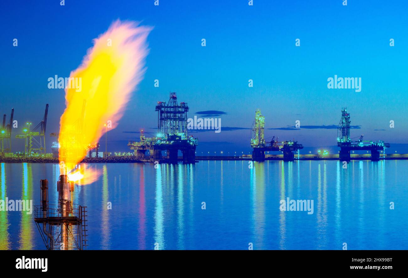 Oli Rigs bei Sonnenaufgang mit Gasflackern im Vordergrund. Konzept: Nordsee Gas, Energiekrise, Russland Ukraine Konflikt, Sanktionen, EU, Europa... Stockfoto