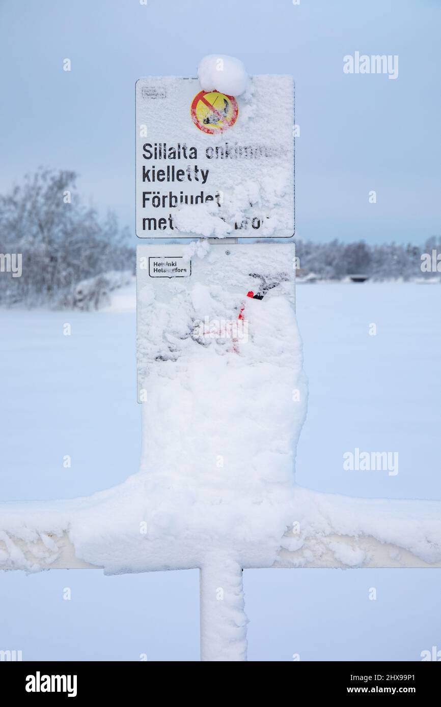 Sillalta onkiminen kielletty. Schneebedecktes Schild nach starkem Schneefall auf Seurasaari brdige in Helsinki, Finnland. Stockfoto