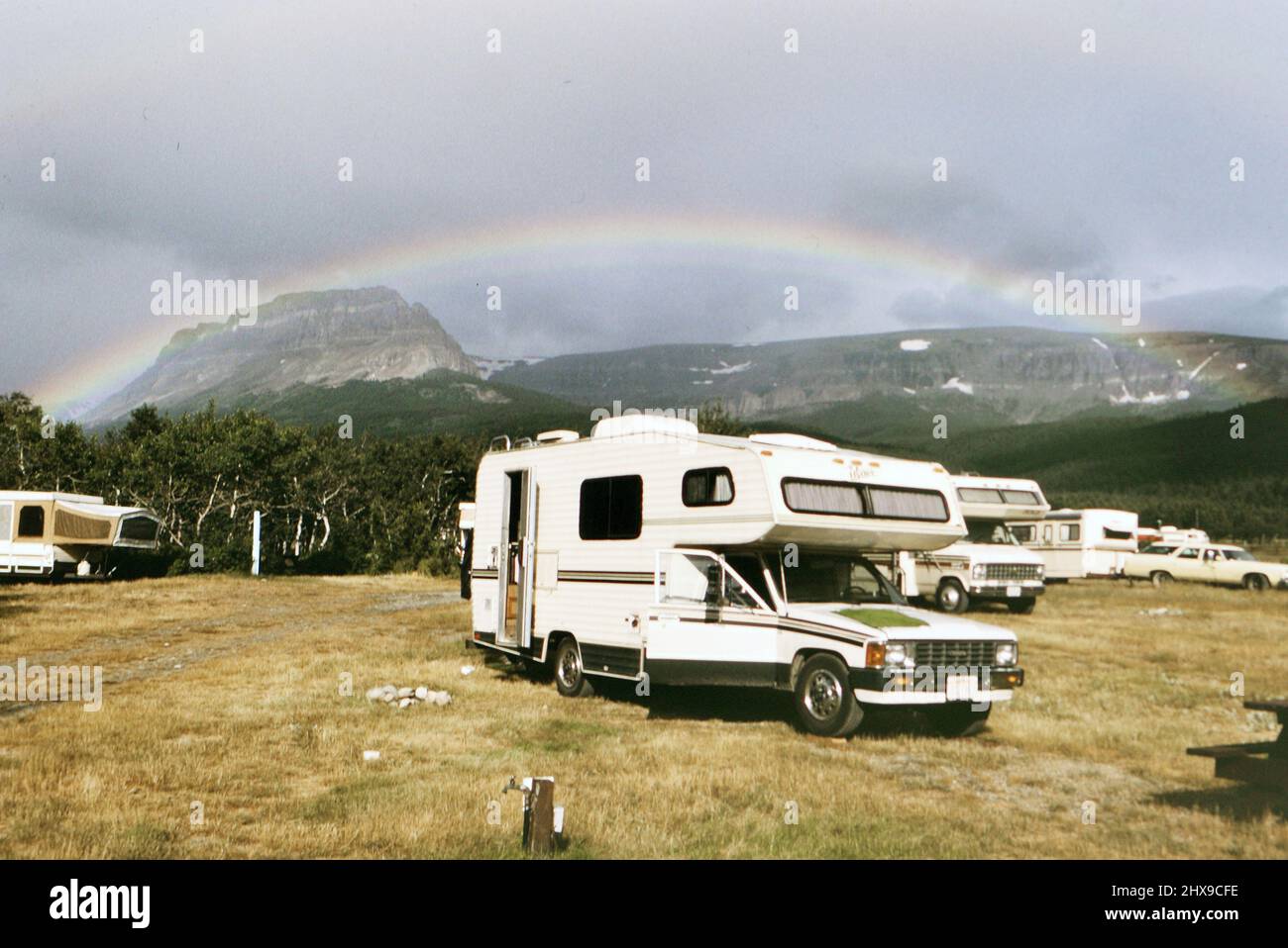 RVS geparkt auf einem Campingplatz mit Regenbogen über ca. 1990 Stockfoto