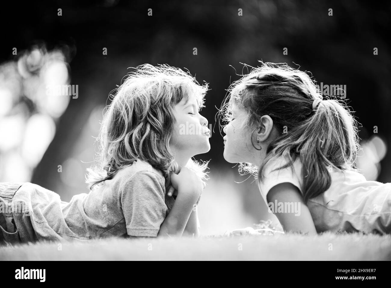 Beziehungen zu Kindern. Nette Liebe. Kleine Kinder küssen im Freien im Park. Stockfoto