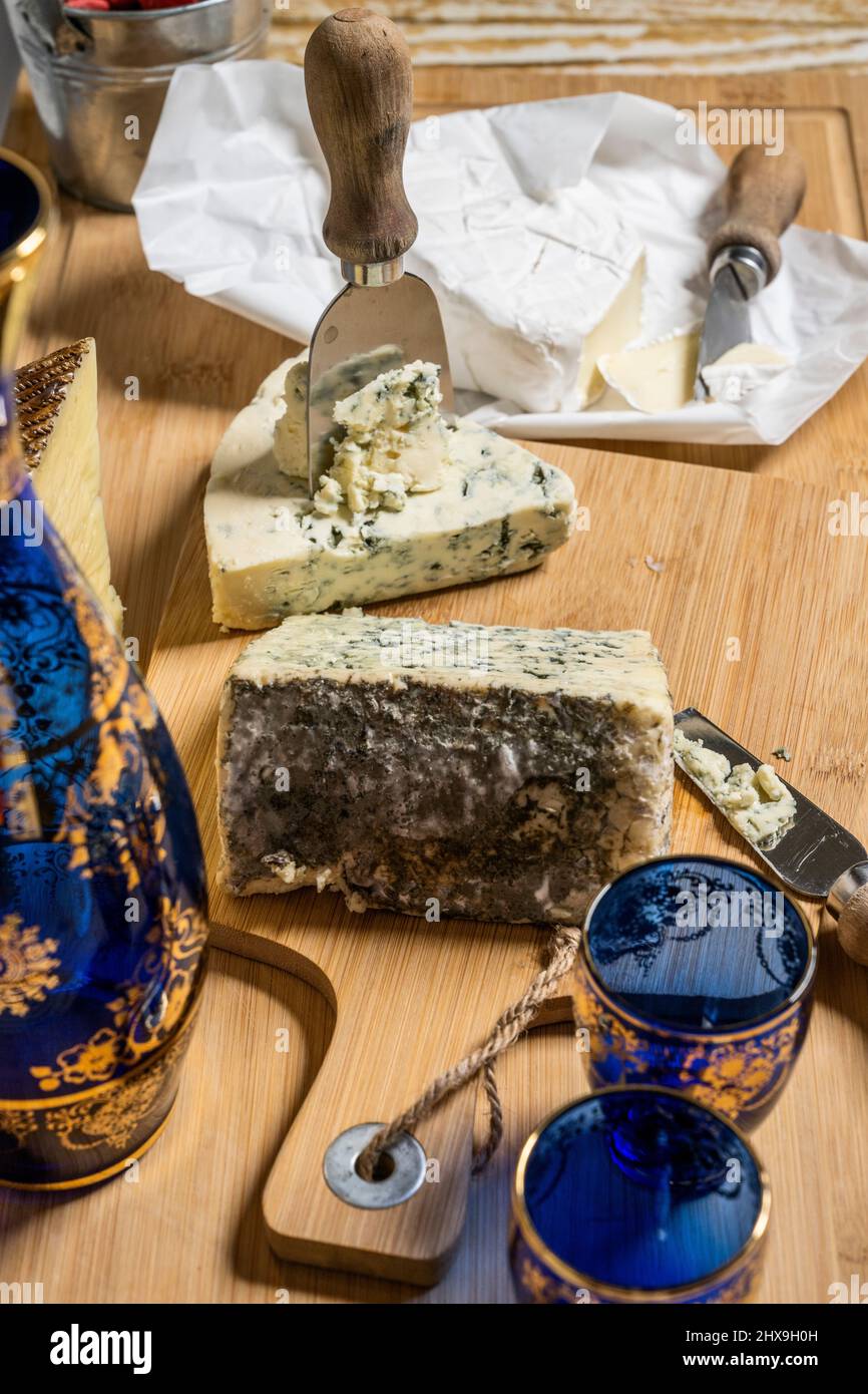 Blauschimmelkäse-Tacos mit Käsemessern und Glasflasche und Brie-Käse Stockfoto