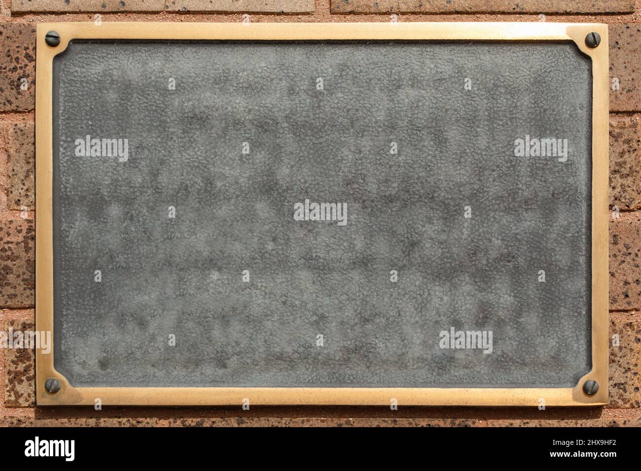 Leere Plakette an der Ziegelwand. Stockfoto