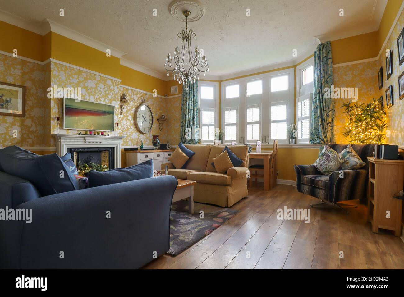 Ein klassisch eingerichtetes marineblaues und gelb-ockerfarbenes Wohnzimmer/Lounge Stockfoto