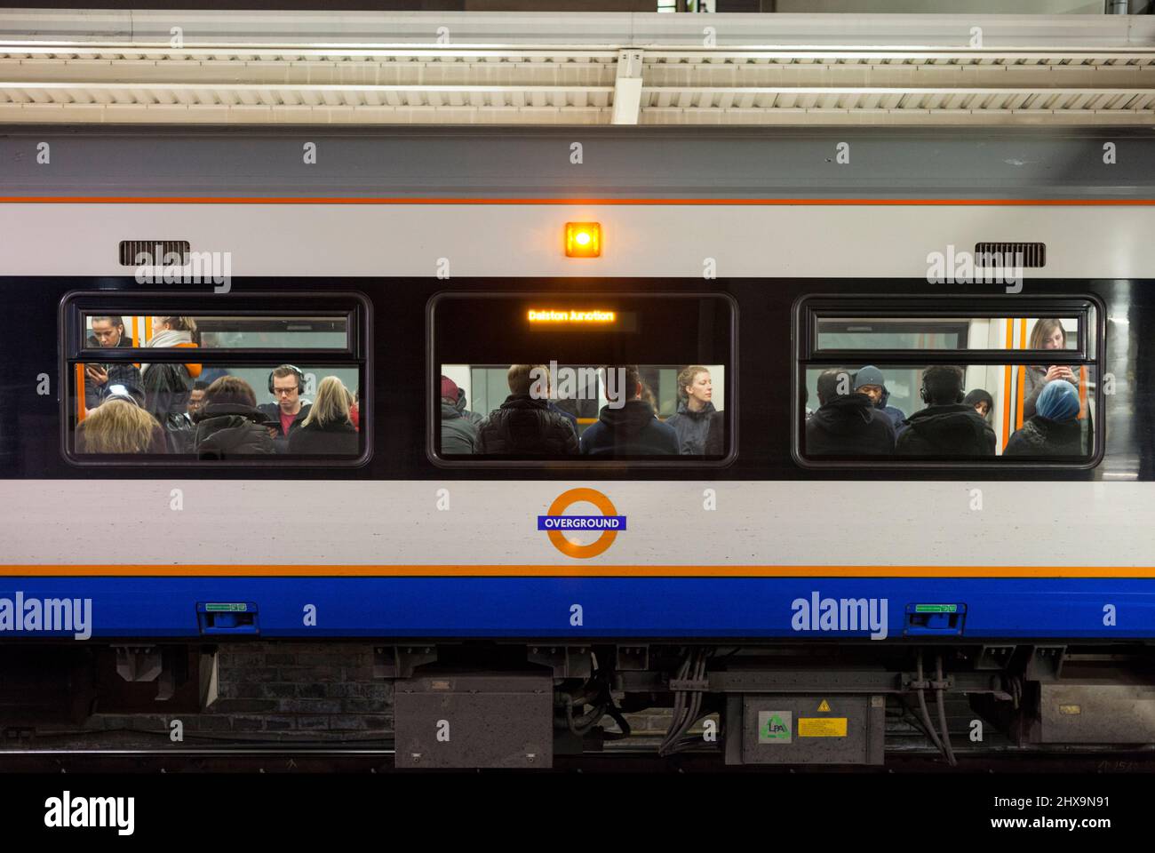 Passagiere in einem gefüllten Zug der London Overground-Klasse 378, der das Overground-Logo trägt Stockfoto