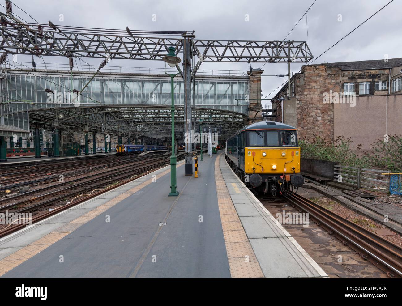 Glasgow Central Station, erhaltene elektrische Lokomotive der Klasse 86 86101, die den leeren Vorrat aus dem Nachtzug des Caledonian Sleeper aus London schleppt Stockfoto
