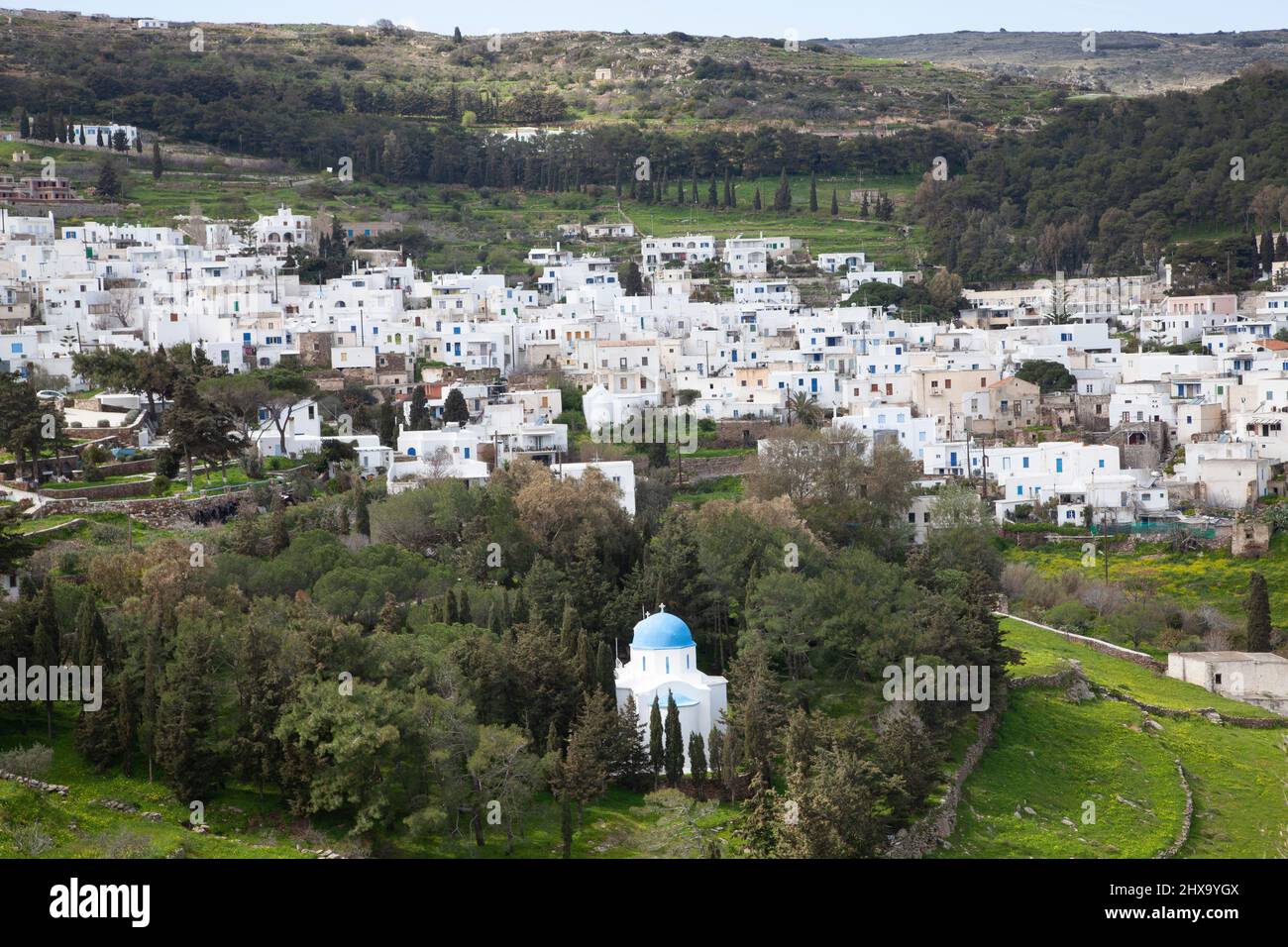 Blue-Domed Kirche in Copse von Bäumen des traditionellen griechischen Dorfes Stockfoto