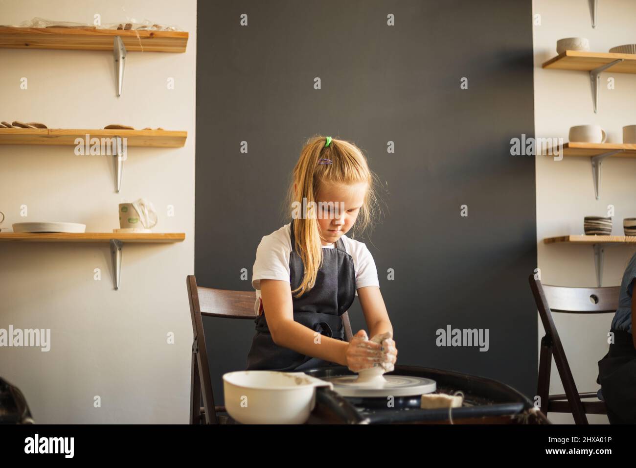 Portrait eines Mädchens, das am Töpferrad arbeitet und Tontopf macht. Stockfoto
