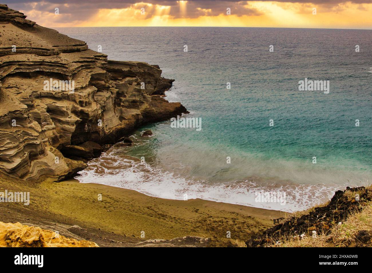 Blick auf Papakolea der grüne Sandstrand auf der großen Insel bei Sonnenuntergang. Stockfoto