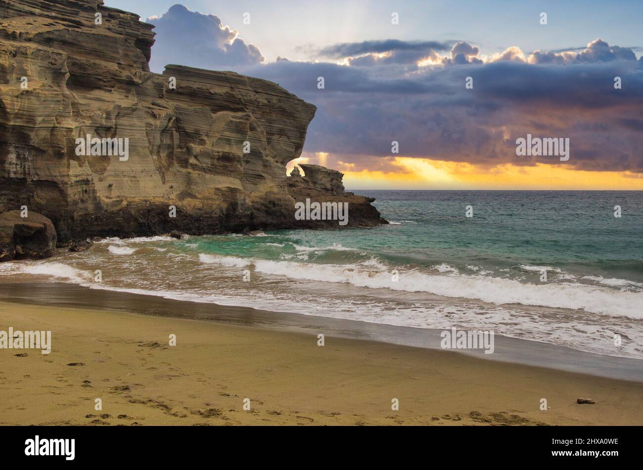 Sonnenuntergang am grünen Sandstrand, bekannt als Papakolea. Stockfoto