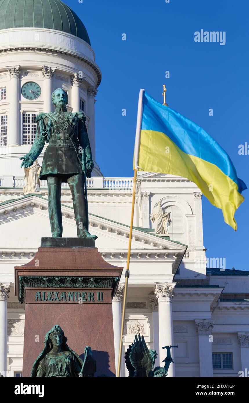 Helsinki, Finnland - 26. Februar 2022: Statue des ehemaligen russischen Zaren Alexander II und ukrainischer Flagge bei einer Kundgebung gegen die russischen Militärankaten Stockfoto