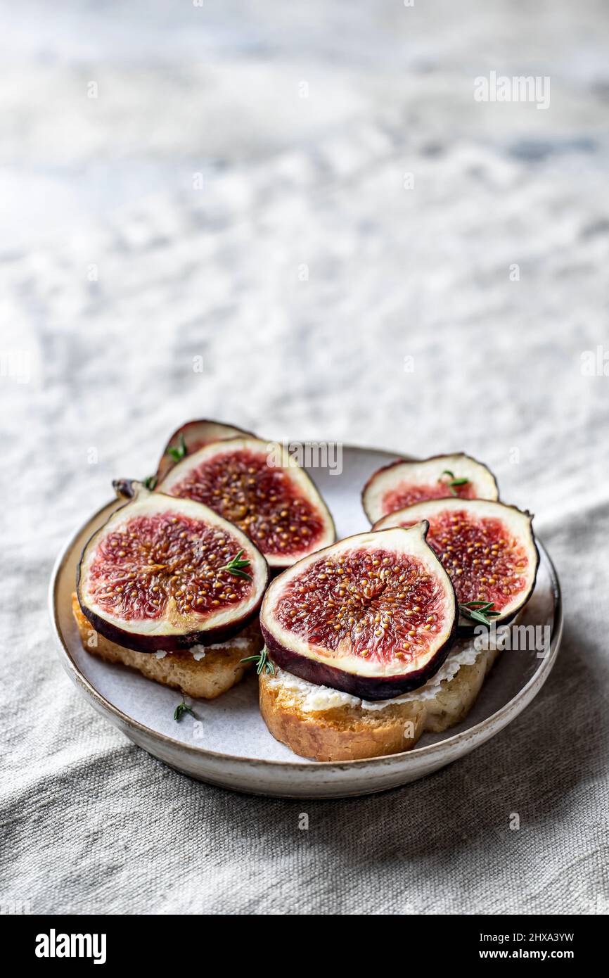 Zwei Sandwiches mit Feigen, Käse, Thymian und Honig auf einer grauen Leinenserviette. Nahaufnahme Stockfoto