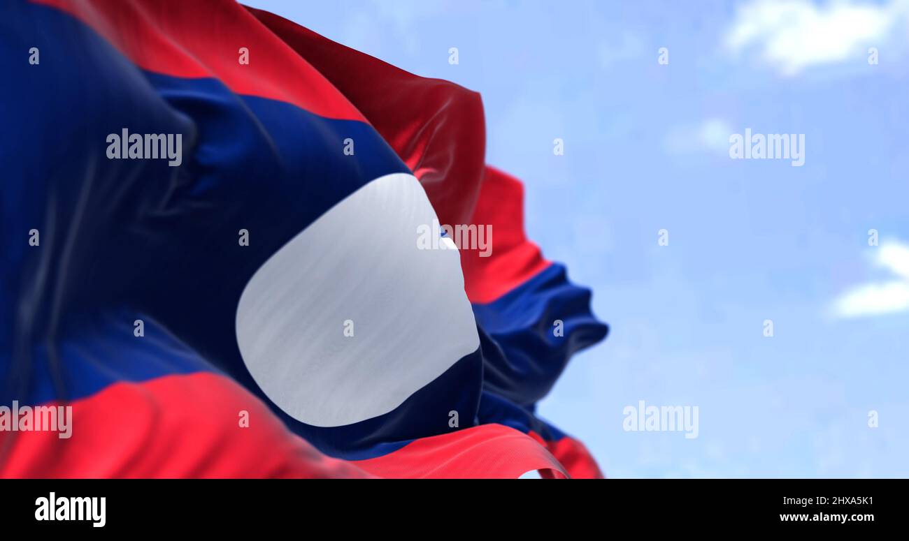 Detail der Nationalflagge von Laos, die an einem klaren Tag im Wind winkt. Laos ist ein sozialistischer Staat und das einzige Binnenland in Südostasien. Se Stockfoto