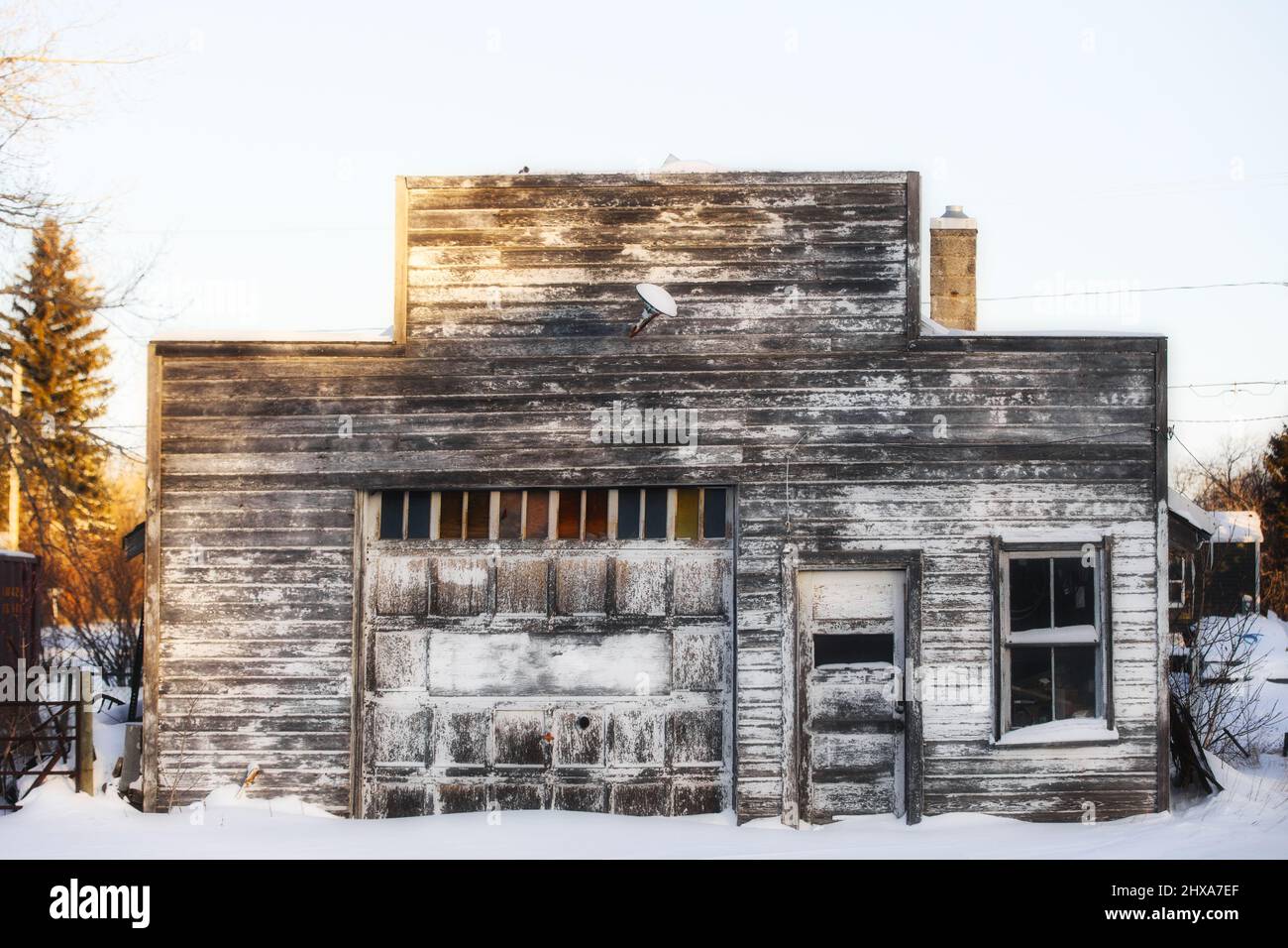 Vorderansicht eines verlassenen Holzwerkstatt mit falscher Front, umgeben von Winterschnee Stockfoto