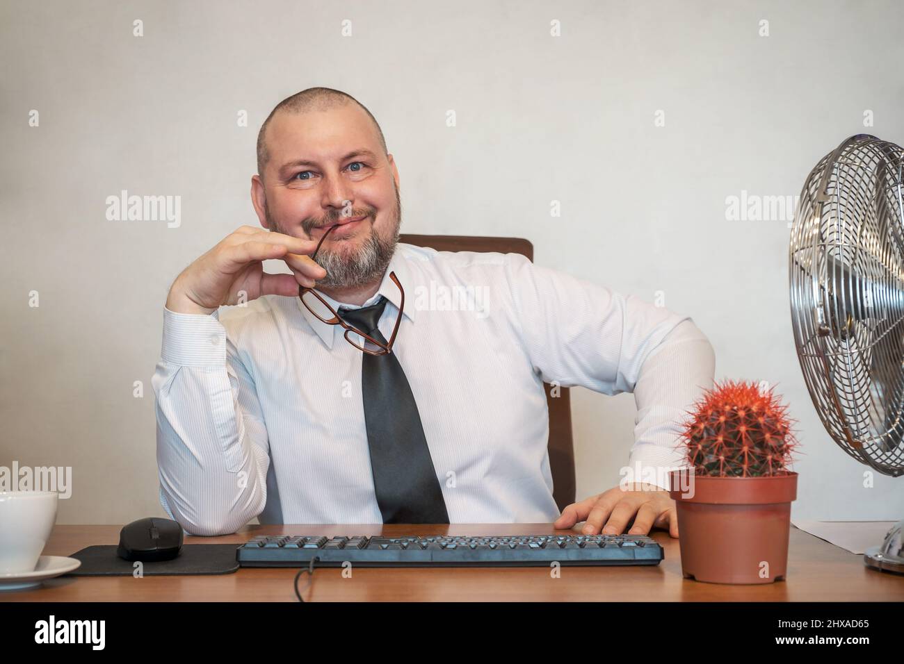 Der Mann stellt komisch die Arbeit eines Geschäftsmannes dar. Er zeigt Zufriedenheit und Freude im Gesicht und in seiner Haltung. Stockfoto
