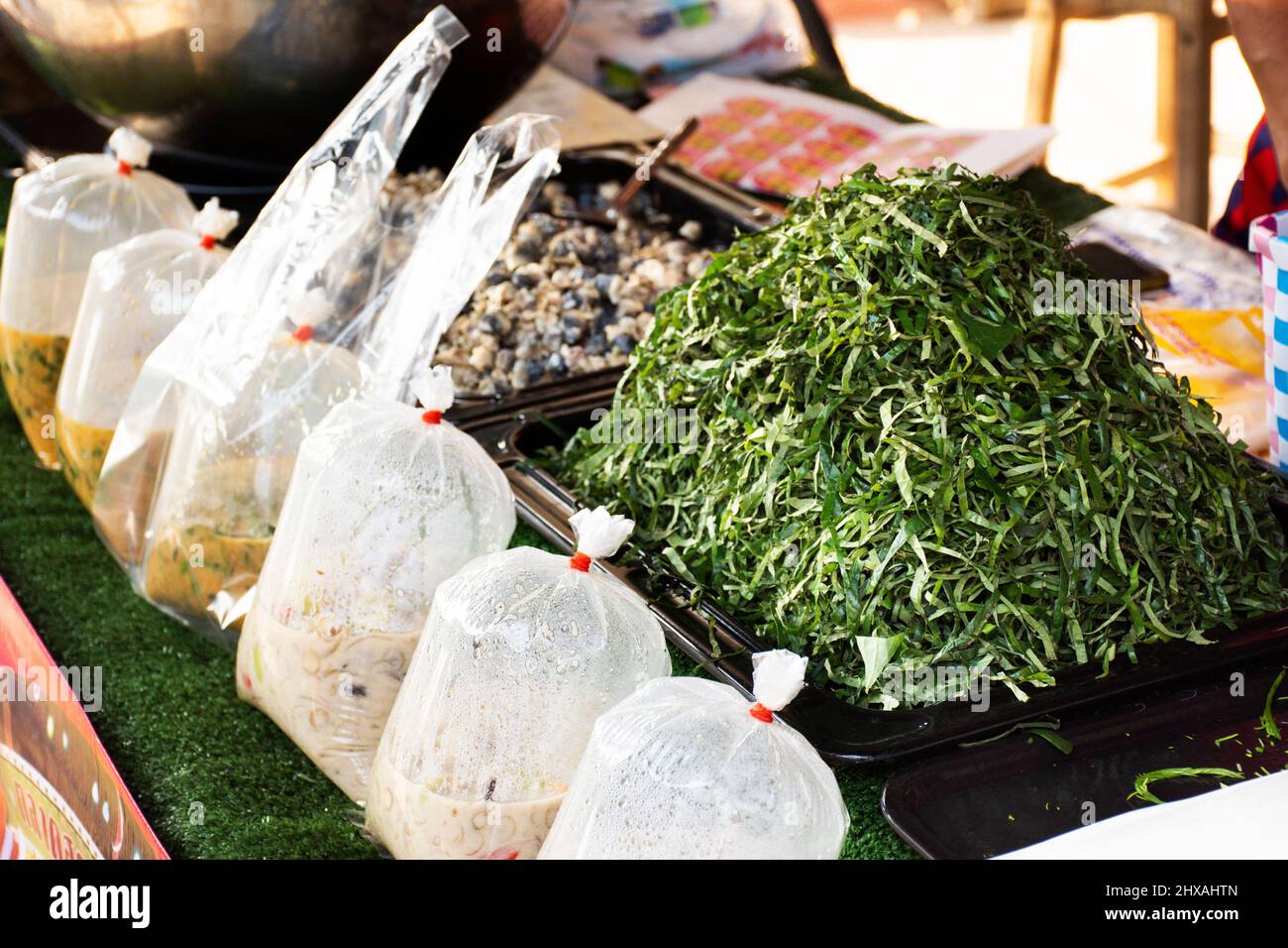 Thailändischer Koch kocht Essen Fusion traditionelle lokale thai-Kurie mit Süßwasser-Fluss Schnecken Herzmuscheln und Betel Pfeifer sarmentosum Blätter zum Verkauf in Sam Khok Stockfoto