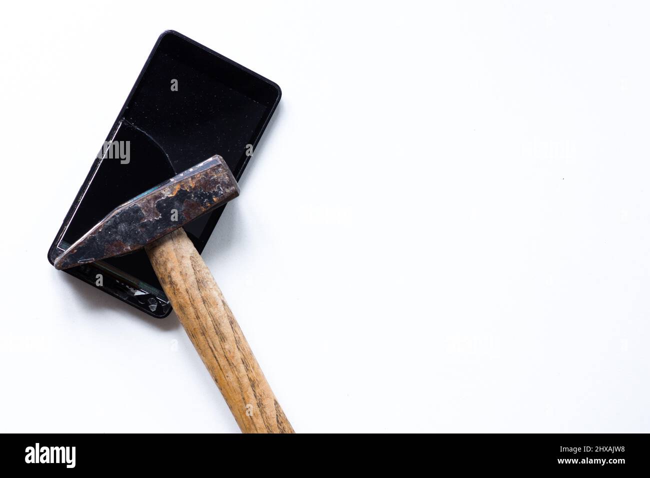Gebrochene berühren Handy auf dem weißen Hintergrund und Hammer Stockfoto