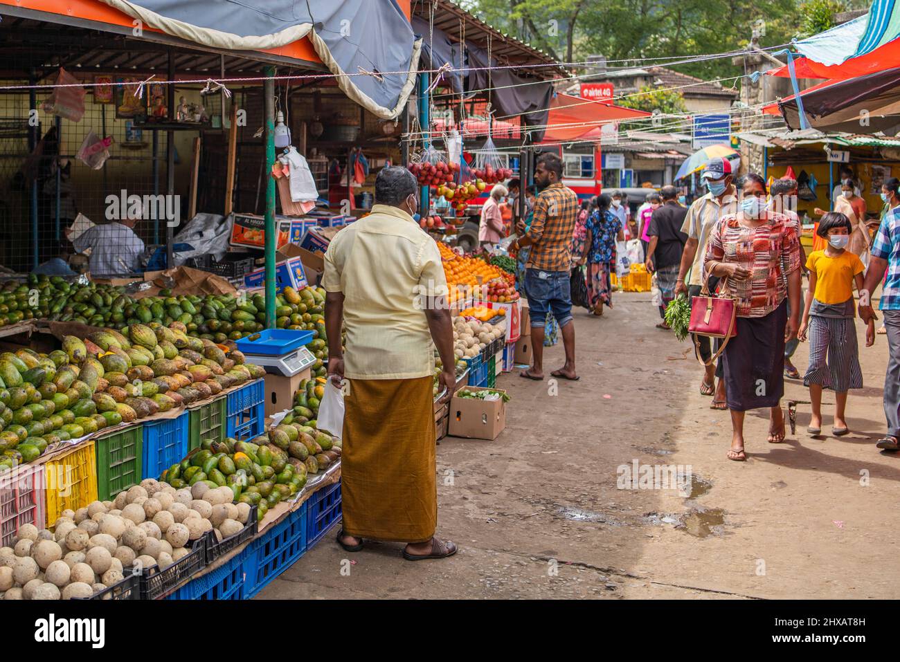 KANDY, SRI LANKA - 20. MÄRZ: Menschen gehen vor Obstständen auf dem Kandy Markt in Sri Lanka Stockfoto