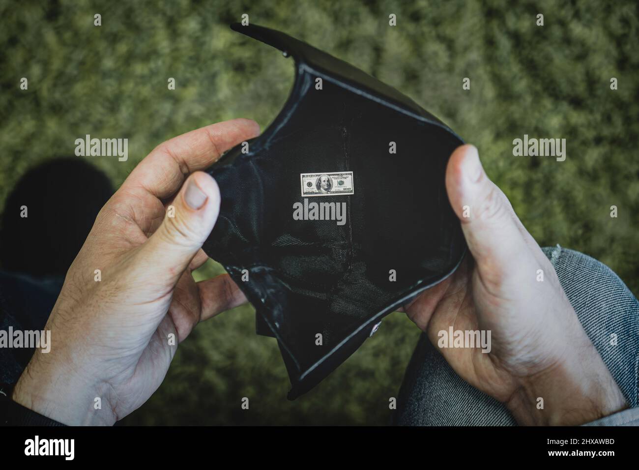 Armutskonzept mit nur einem kleinen 100-Dollar-Schein in einer Ledertasche. Wirtschaftskrise-Konzept. Stockfoto