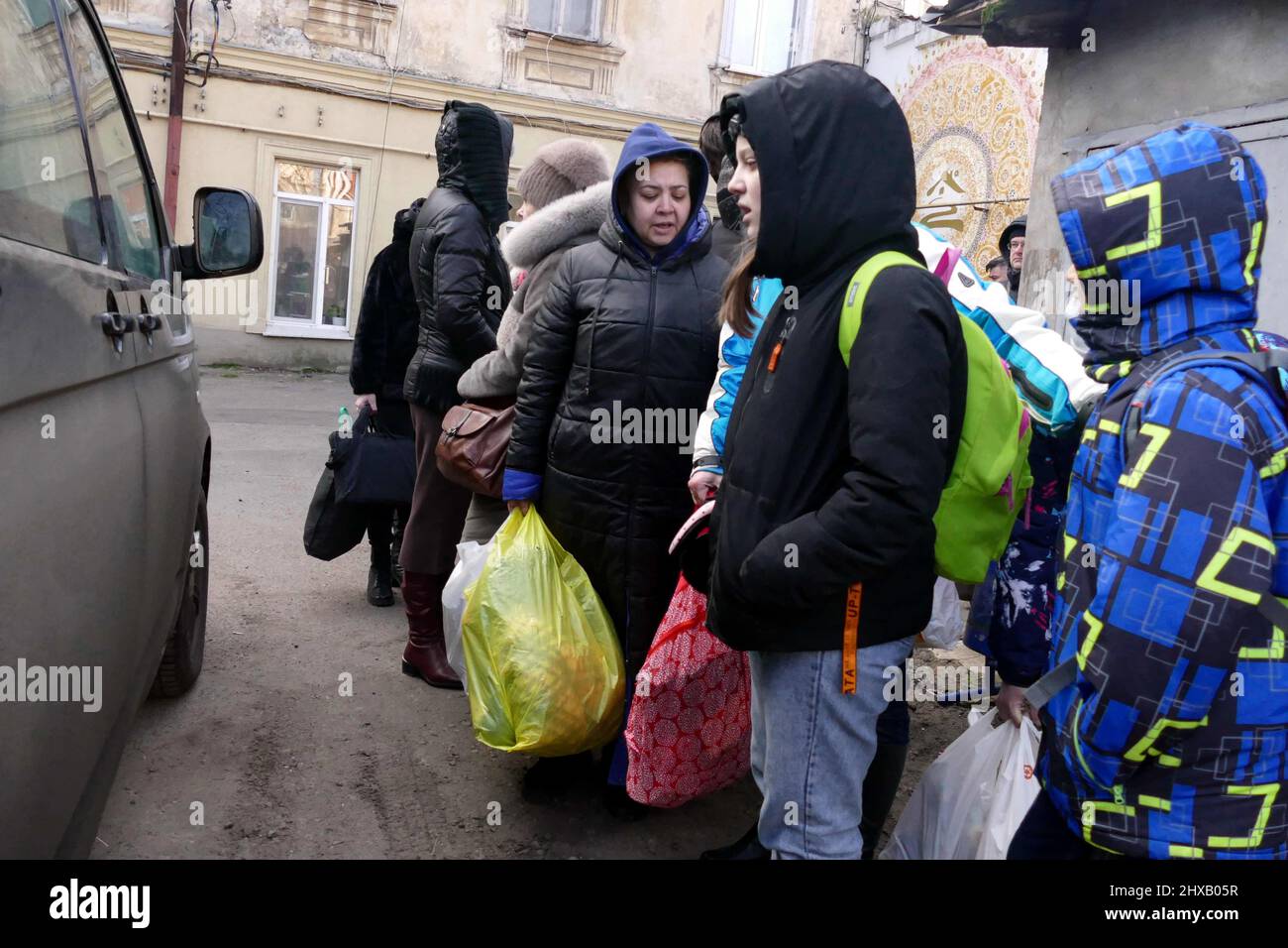 ODESA, UKRAINE - 10. MÄRZ 2022 - Menschen, die vor der russischen Invasion fliehen, sind in der Nähe eines kostenlosen Evakuierungsbusses versammelt, der sie zur Grenze bringen soll Stockfoto
