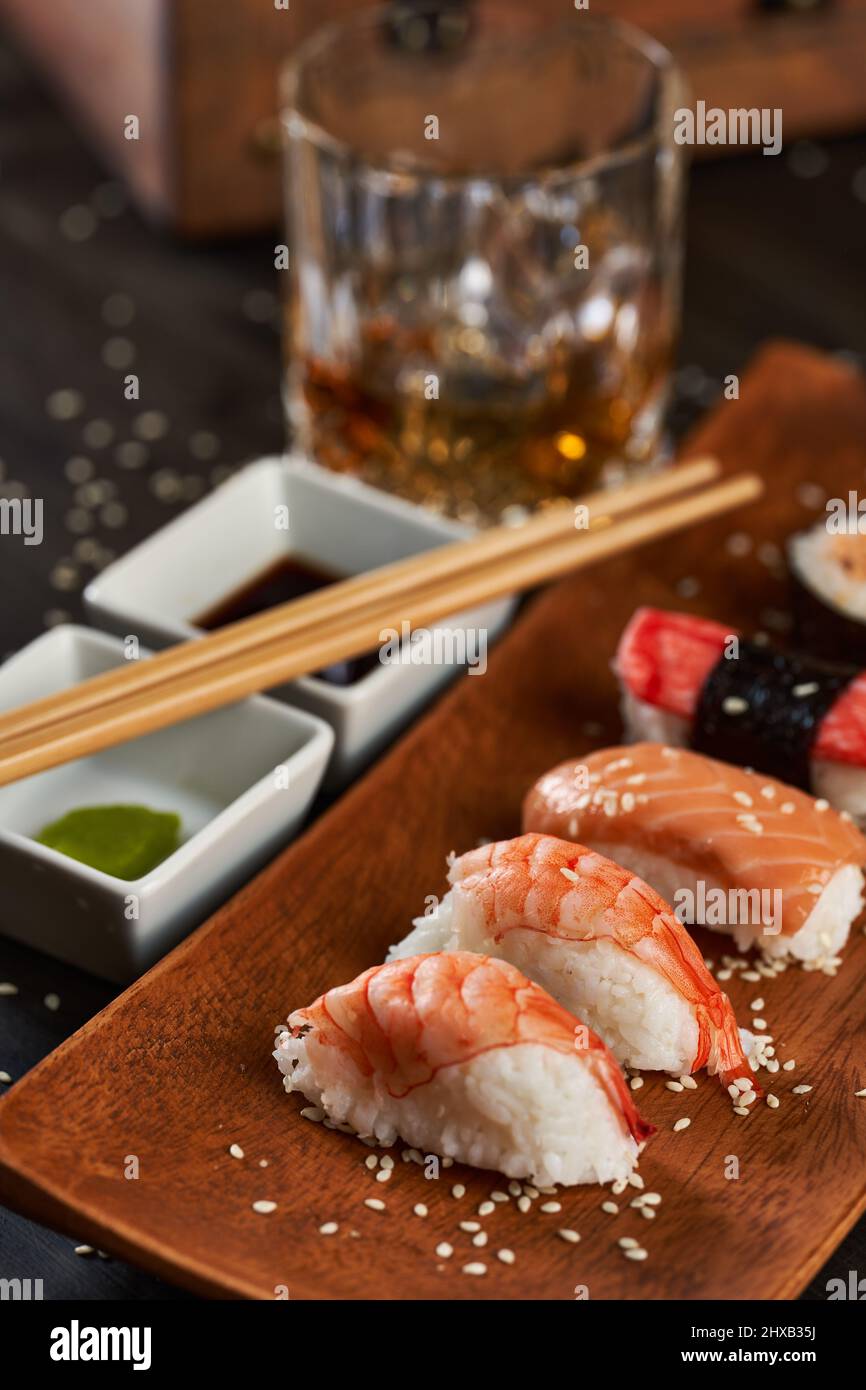 Frisches Sushi-Sortiment auf rustikalem Holzteller Stockfoto