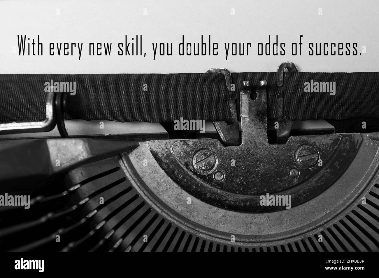 Motivierendes Zitat auf einer alten Schreibmaschine – mit jeder neuen Fähigkeit verdoppeln Sie Ihre Erfolgsaussichten. Stockfoto