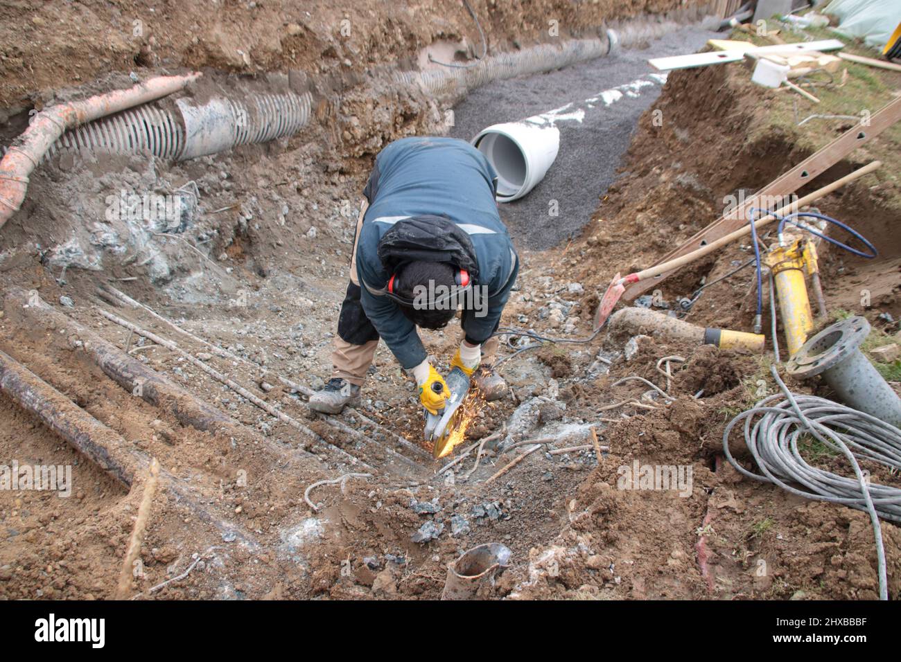Arbeiter in einer Grube arbeitet mit einem Winkelschleifer Stockfoto