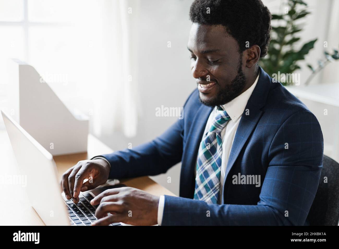 Business african Mann arbeitet im modernen Büro mit Computer-Laptop - Fokus auf das rechte Auge Stockfoto
