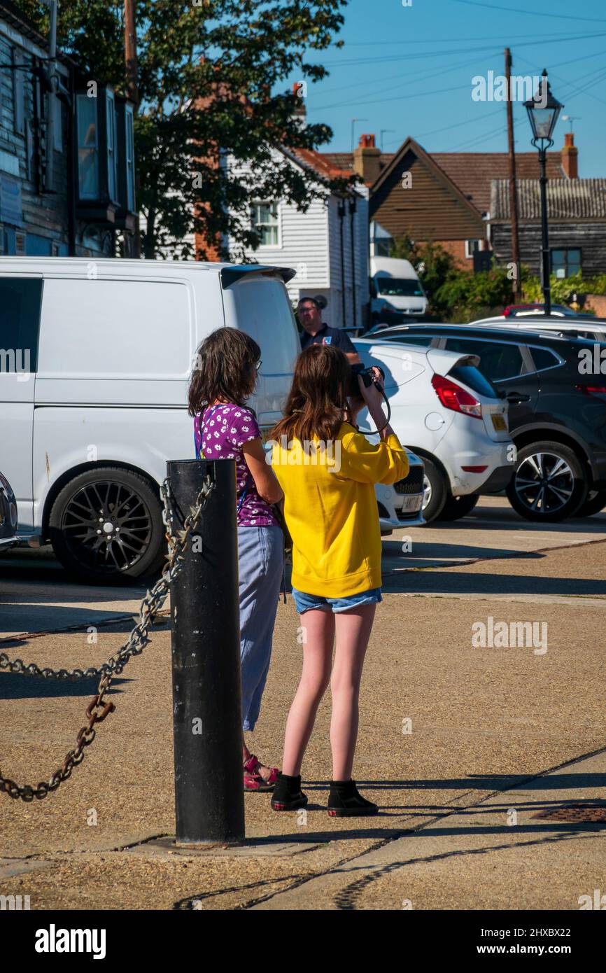 Zwei Mädchen im Teenageralter fotografieren die geschäftige Hythe am Fluss Chelmer in Maldon, Essex, Großbritannien Stockfoto