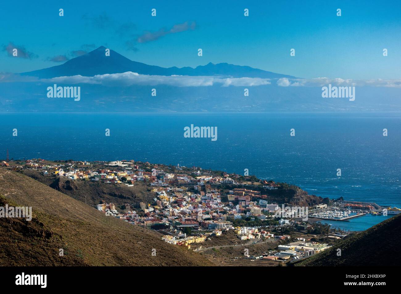 Blick von La Gomera auf die Stadt San Sebastian im Vordergrund und den Vulkan Teide auf Teneriffa in der Ferne. Kanarische Inseln, Spanien Stockfoto