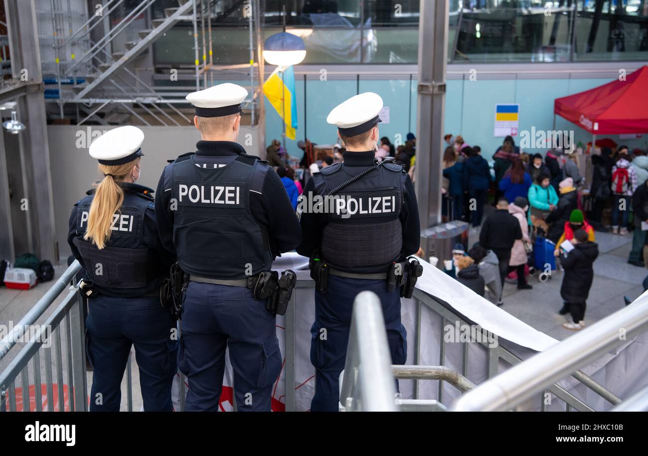 München, Deutschland. 11. März 2022. Polizeibeamte beobachten die Ankunft von Flüchtlingen aus der Ukraine am Hauptbahnhof. Quelle: Sven Hoppe/dpa/Alamy Live News Stockfoto
