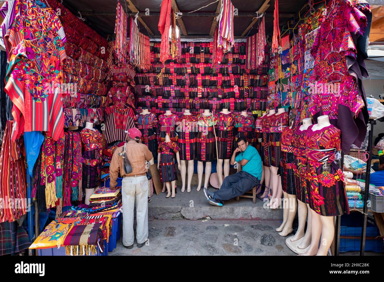 Kleider und Stoffe werden auf dem farbenfrohen wöchentlichen Chichicastenango Mayan Market in Guatemala, Zentralamerika, verkauft. Stockfoto