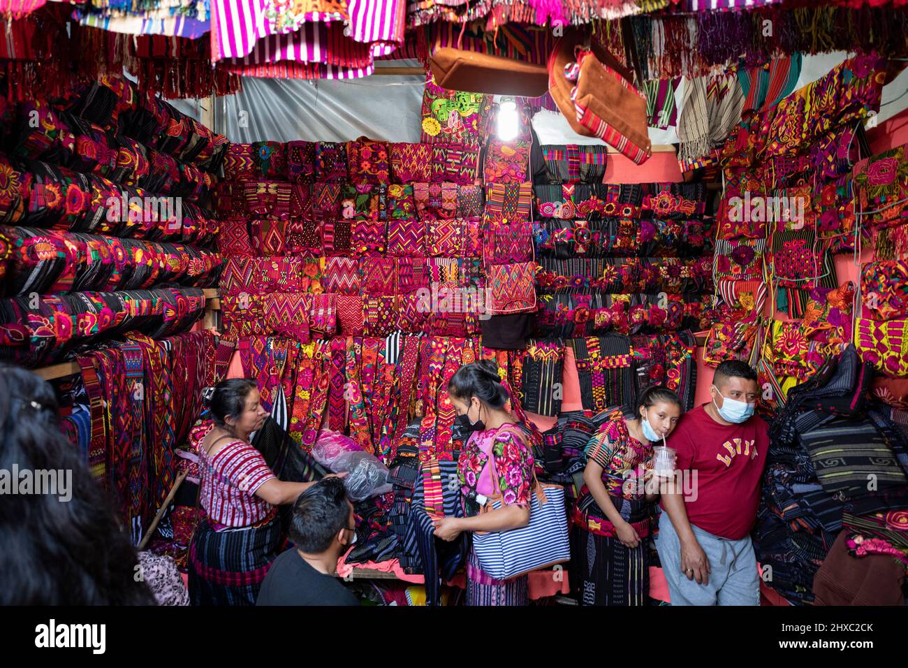 Kleider und Stoffe werden auf dem farbenfrohen wöchentlichen Chichicastenango Mayan Market in Guatemala, Zentralamerika, verkauft. Stockfoto