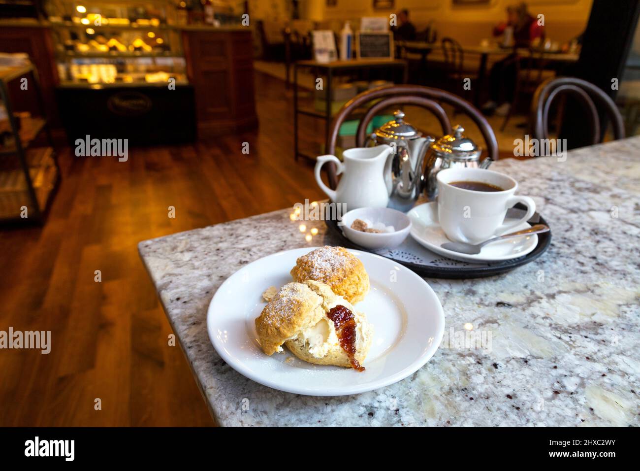 Scones mit Marmelade und Creme und Tee im Harriets Cafe Tearooms, Norwich, Norfolk, Großbritannien Stockfoto