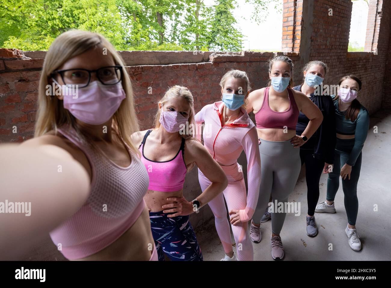 Selfie-Gruppe von weiblichen Sportteams. Sportliche Frauen tragen Sportkleidung und Gesichtsmasken zum Schutz vor Corona- oder Covid-Infektionen und machen ein Gruppenfoto. Influencer und Fitness-Vlogger. Hochwertige Fotos Stockfoto