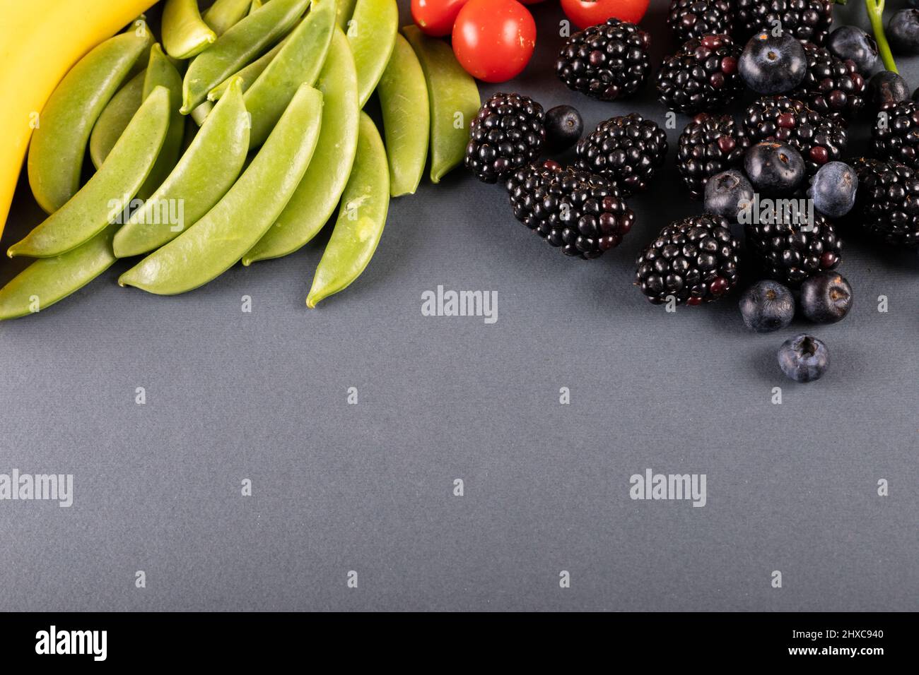 Nahaufnahme von Blaubeeren und Brombeeren mit Gemüse auf dem Tisch mit Platz für Kopien Stockfoto