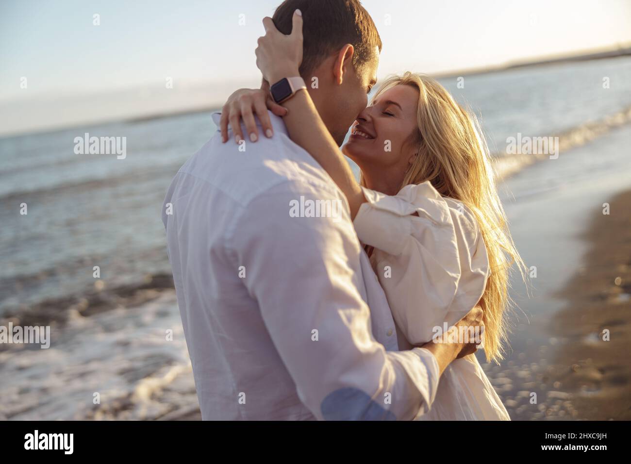 Porträt eines sorglosen Paares, das sich am Strand küsst Stockfoto