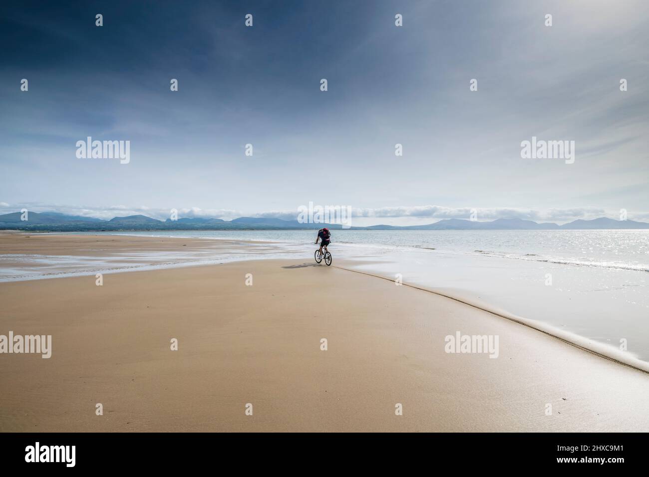 Einsamer Radfahrer am Newborough Beach am Anglesey Ynys Mon North Wales, großbritannien Stockfoto