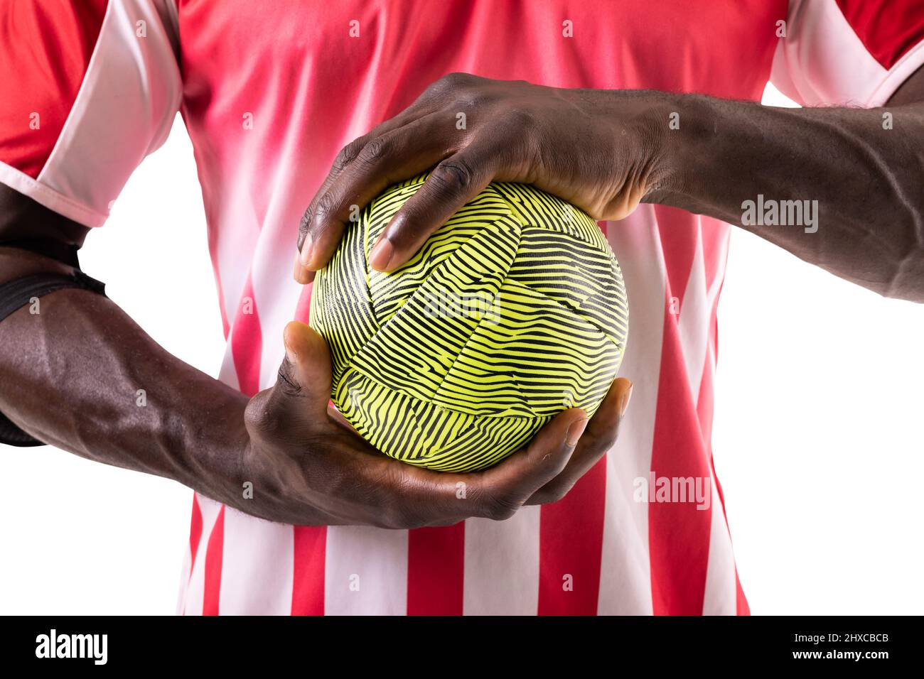 Mittelteil des afroamerikanischen männlichen Handballspielers in roter Uniform mit grüner Kugel Stockfoto