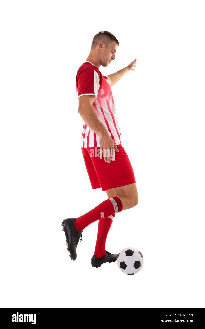 Junger kaukasischer Athlet tritt den Fußball vor weißem Hintergrund Stockfoto