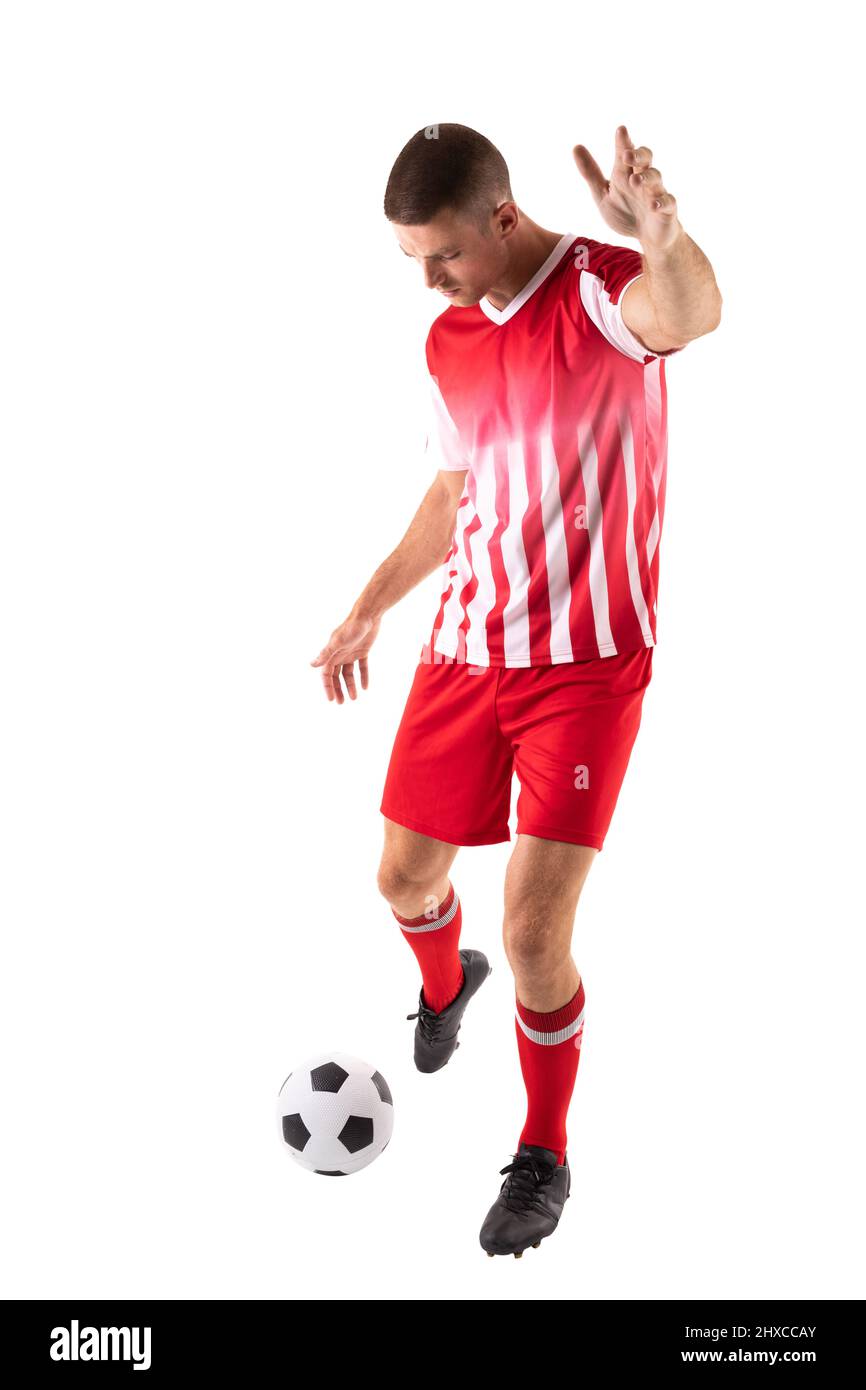 In voller Länge kickte ein junger kaukasischer Athlet den Fußball vor weißem Hintergrund Stockfoto