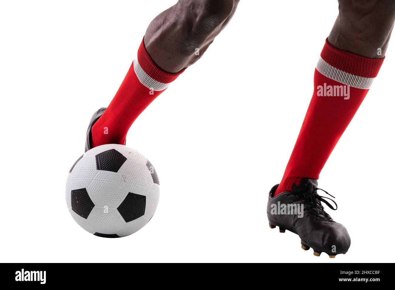 Niedriger Abschnitt des jungen afrikanischen amerikanischen Athleten, der den Fußball vor weißem Hintergrund tritt Stockfoto
