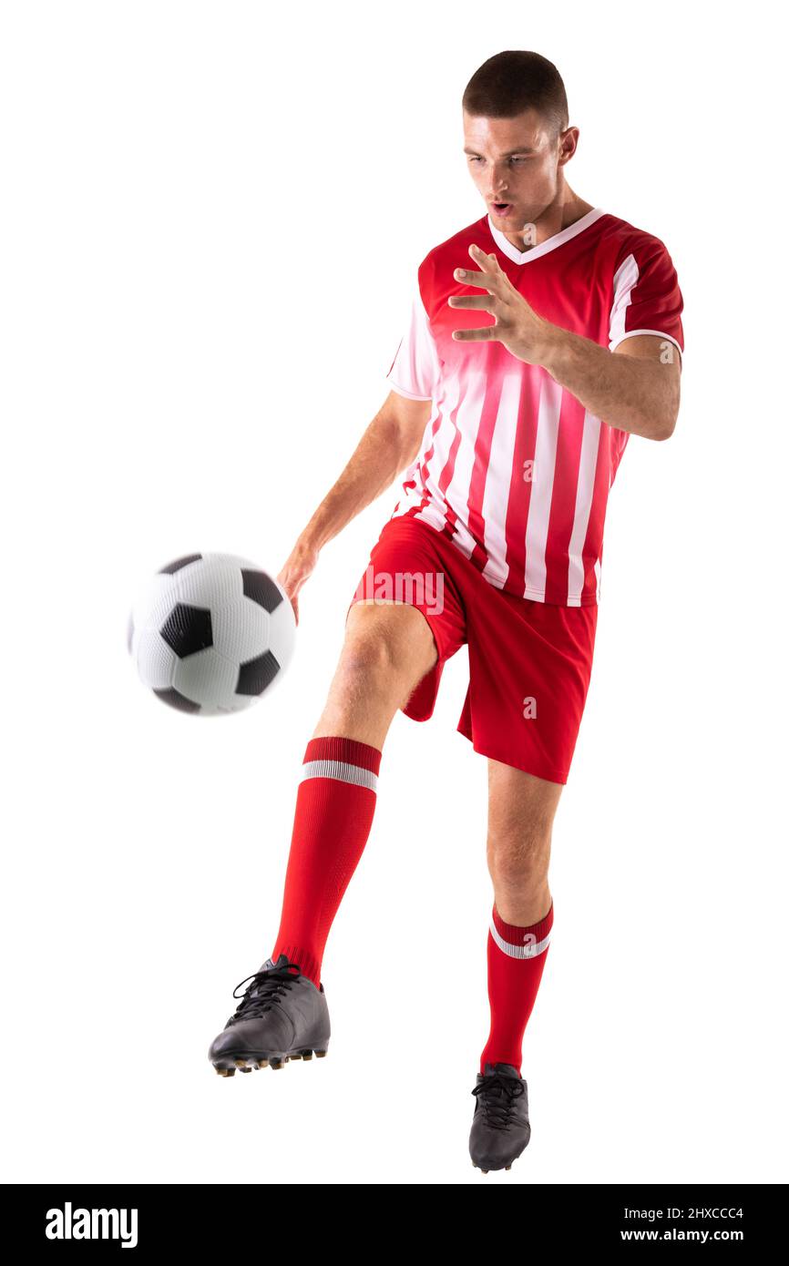 Selbstbewusster junger kaukasischer Athlet, der den Fußball vor weißem Hintergrund tritt Stockfoto